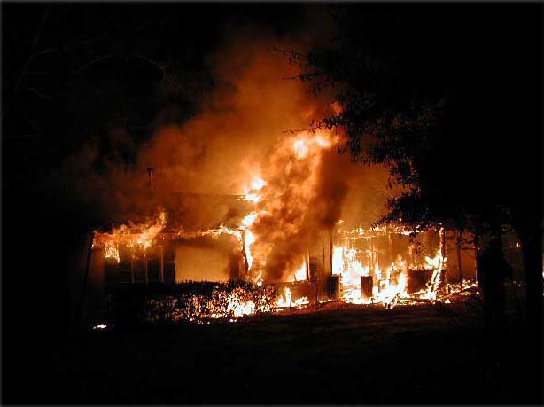 a dark photo of a house on fire