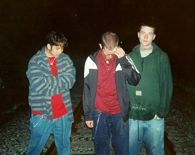 the band looking down at the train tracks they're standing on